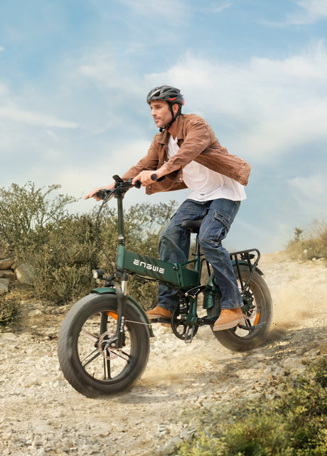 a man wearing a helmet riding a mountain green engwe engine pro 2.0 e fatbike on the sand