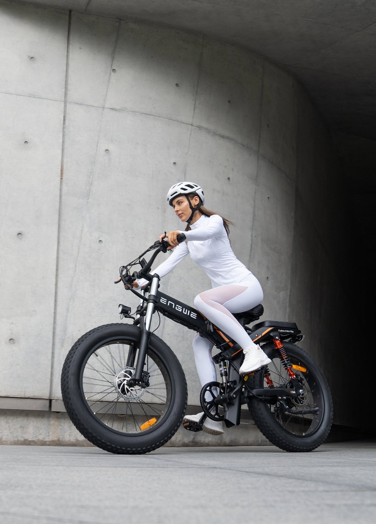 a woman riding a black engwe x24 folding e bike on the road