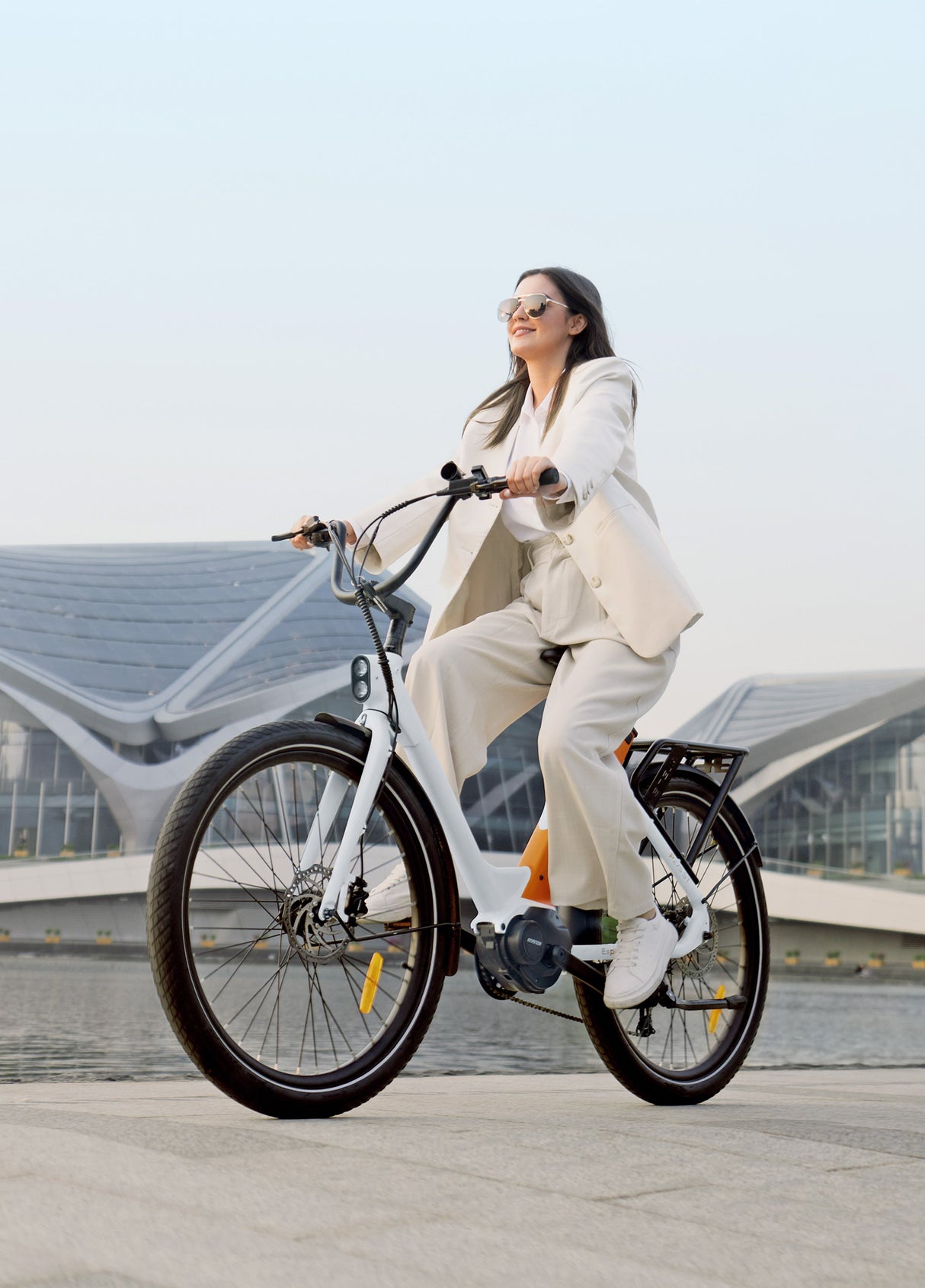 a woman riding a white-orange engwe p275 st urban bike on the road